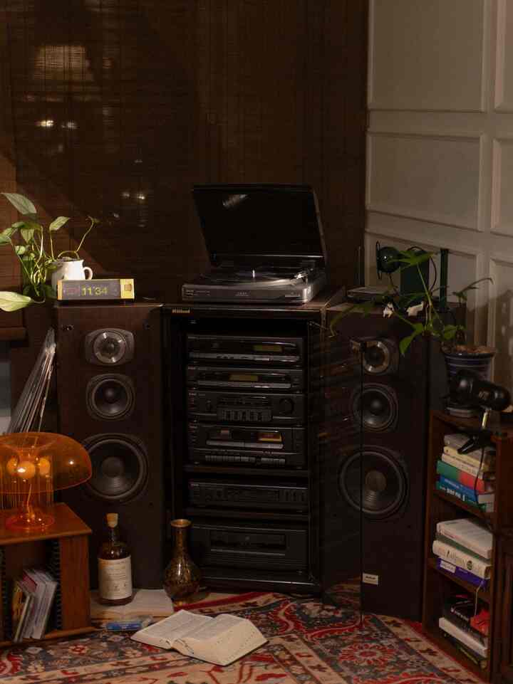 Warm brown-toned study space featuring a vintage audio system and bookshelf in a retro style interior