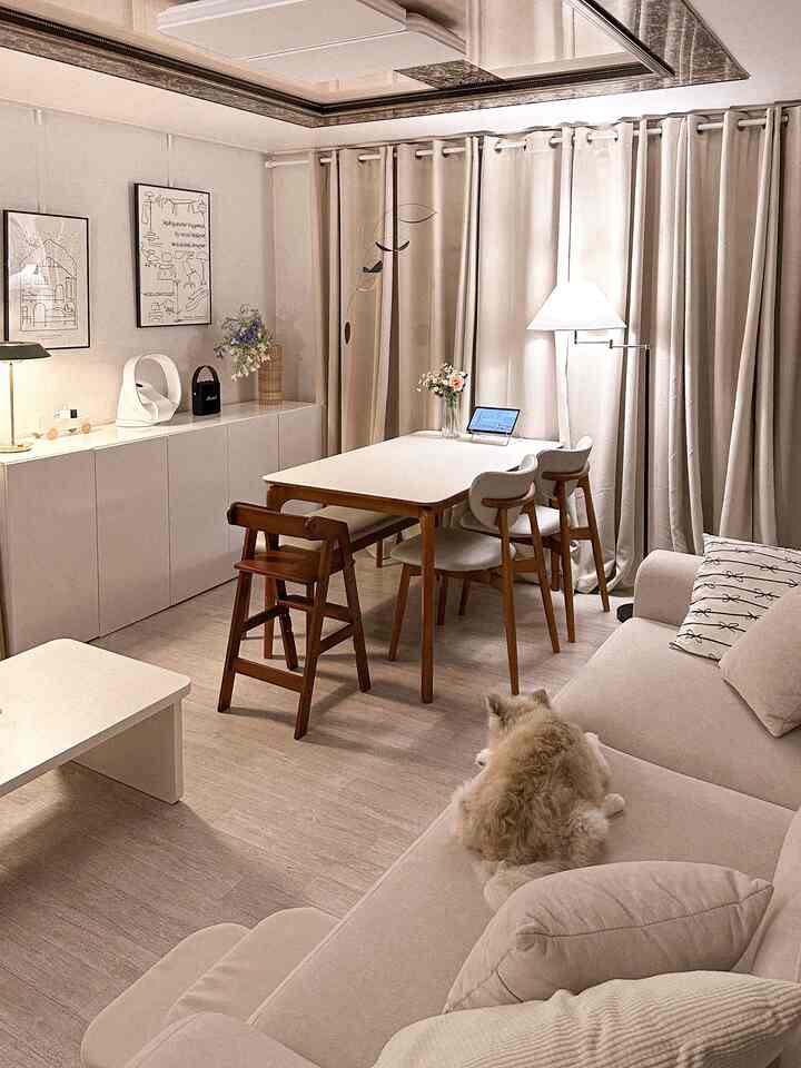 ベージュと木目調が調和したリビング、木製ダイニングテーブルと子供用ハイチェアが配置された温かみのある家族空間