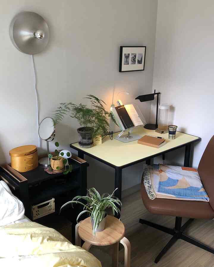 ナチュラルカラーと木目調が調和するコンパクトなホームオフィス、デスクやチェア、植物が配置された雰囲気のあるインテリア