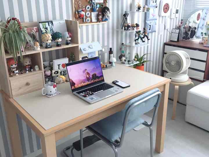 ブルーと木目調が調和したコンパクトなホームオフィス空間、木製デスクとチェア、フィギュアが飾られた整った作業スペース