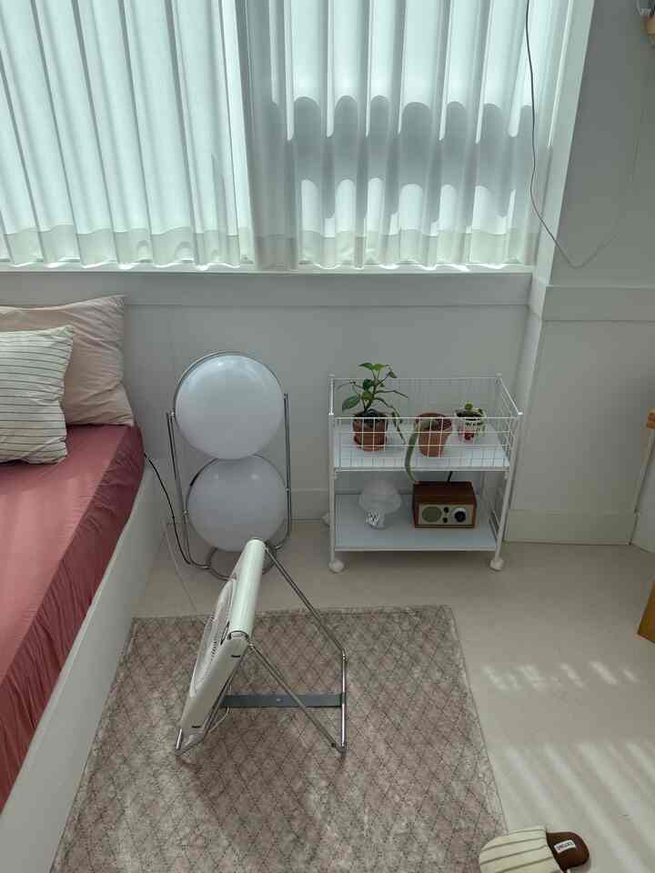 White and beige toned bedroom featuring a sofa bed and rug creating cozy atmosphere