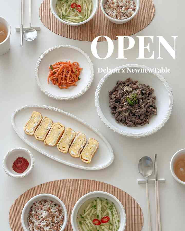 白とベージュのトーンが調和した、ミニマルでモダンなダイニングスペースに韓国風の食器が美しく配置されている様子