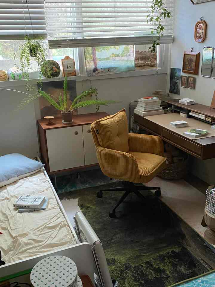 ウッドトーンと黄色が映える寝室兼ホームオフィス、机とチェアが配置された落ち着いた雰囲気の空間