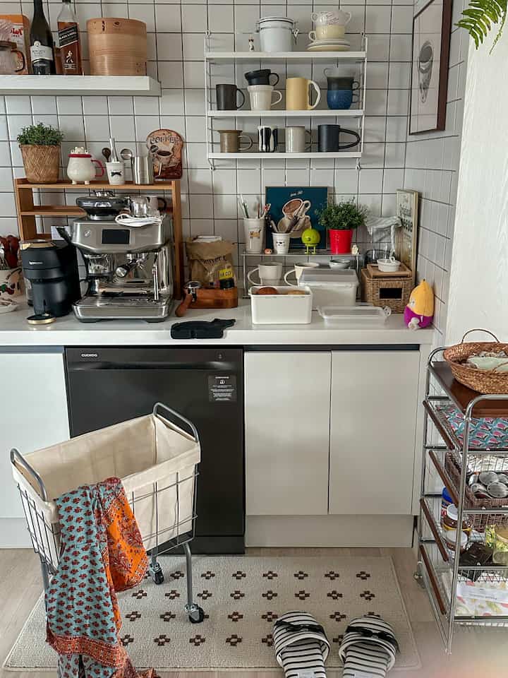 白と茶色のトーンのキッチン、コーヒーマシンとマグカップが配置された雰囲気のあるおうちカフェ空間