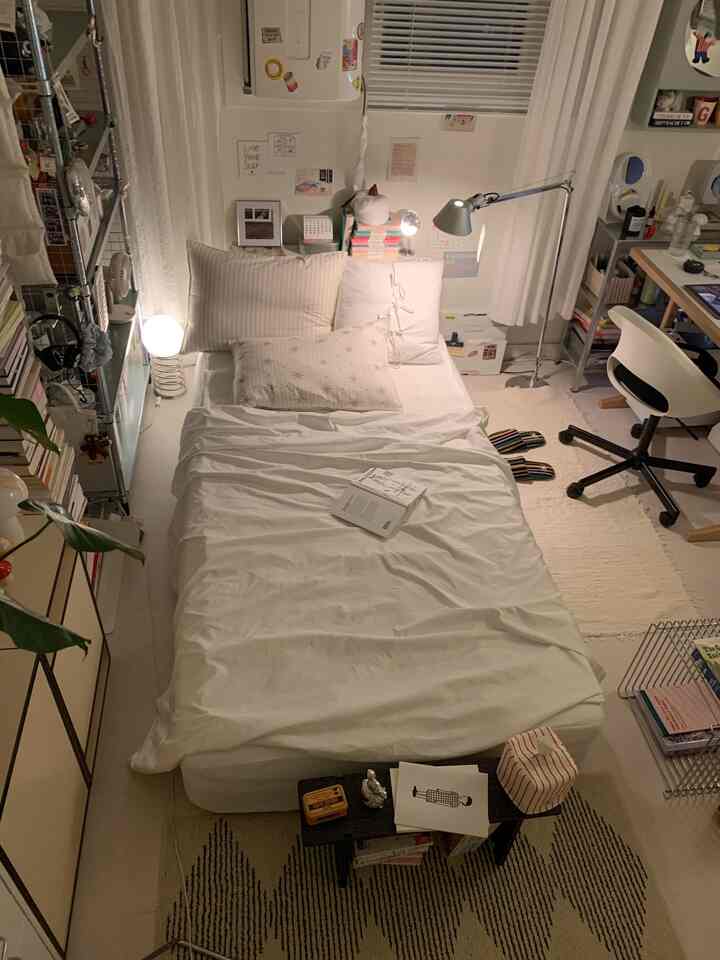 White-toned small bedroom featuring a centrally placed bed and desk, creating a cozy and modern atmosphere