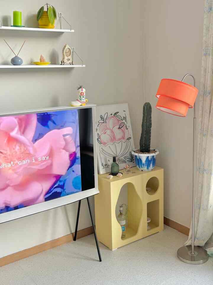 アイボリー色の壁と黄色のキャビネット、フロアランプが置かれたミニマルなリビングルーム