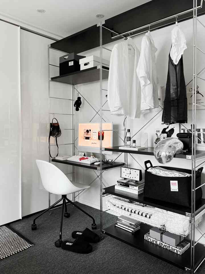 ホワイトの壁とモノトーンのブラック棚、デスク・チェアが調和したコンパクトなホームオフィス兼収納スペース