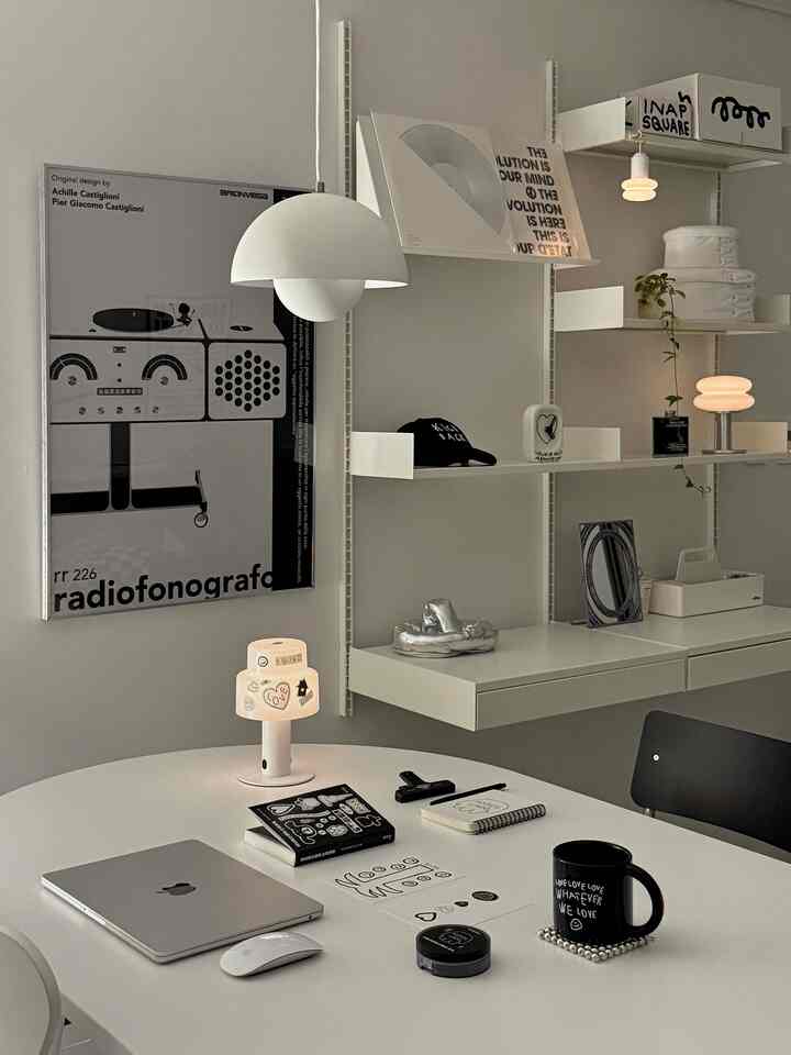 白と黒のモノトーンの書斎兼ダイニングルーム、モダンな家具と温かみのある照明が配置された雰囲気のあるインテリア