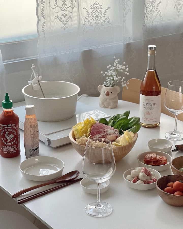 白を基調としたキッチンダイニング、モダンで清潔感のある空間に新鮮な食材と食器が配置されている