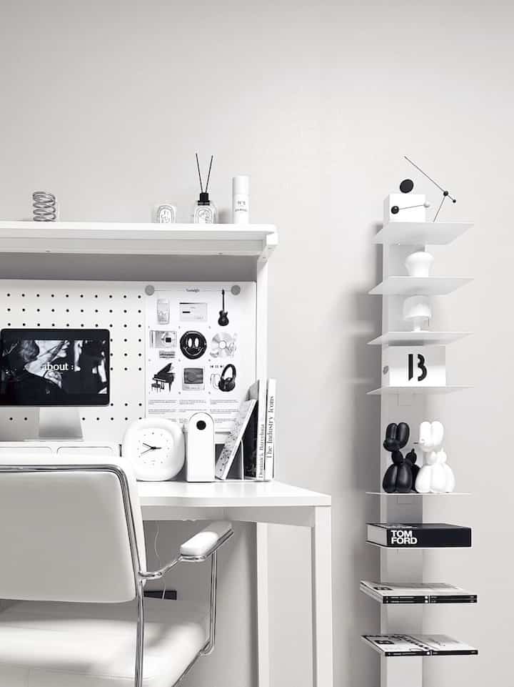 Bright and clean white monotone study space with white desk, chair, and minimalist shelving neatly arranged