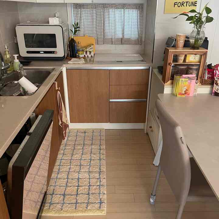 白と茶色のトーンのキッチン、新しいフロアマットが置かれた整頓された居心地の良い空間