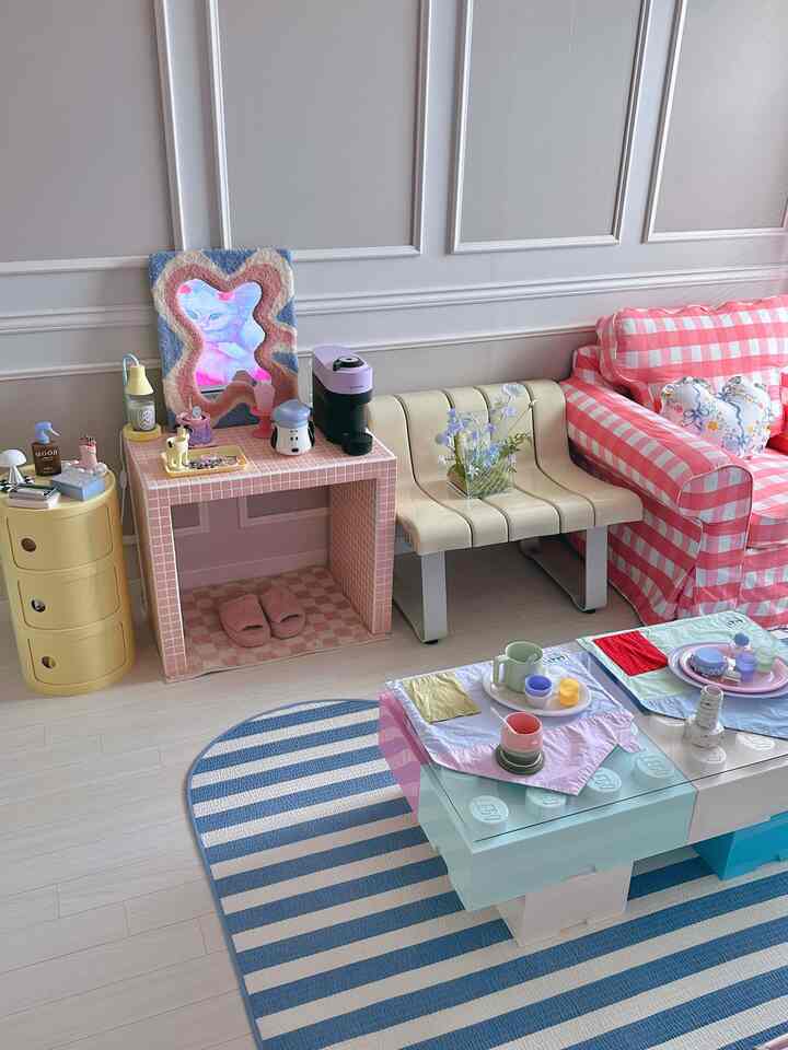 ピンクのチェック柄ソファと黄色の収納がある狭いリビング、おうちカフェスペースが調和した雰囲気のあるインテリア