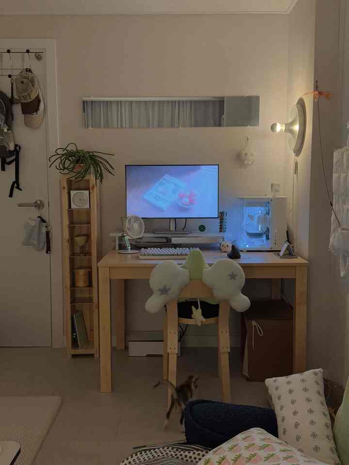 ナチュラルな色調のホームオフィス、木製デスクと椅子、猫が動く落ち着いた作業環境