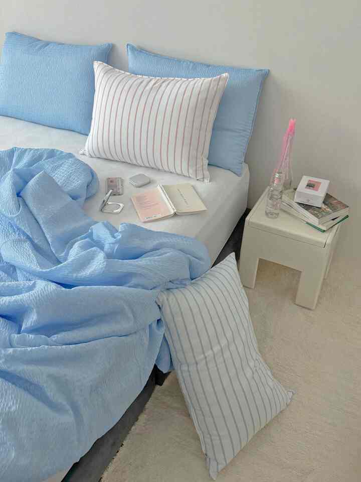 Soft blue and white toned bedroom featuring blue bedding and pillows creating a cozy atmosphere