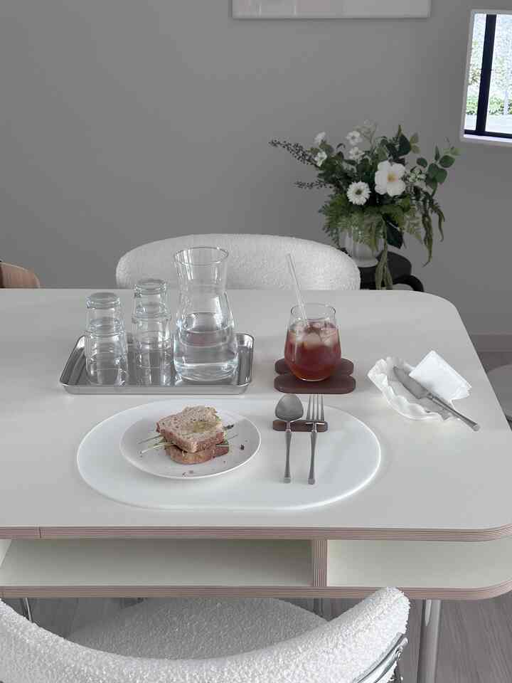 White-toned dining room featuring mid-century modern table and chairs, minimalist space with home cafe vibe