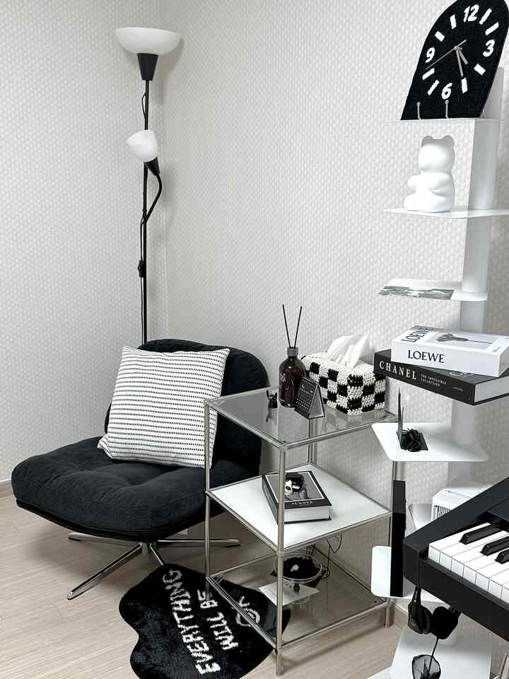 ブラックとホワイトのモノトーンの小さな趣味の部屋、電子ピアノと一人用回転アームチェアが配置されたシンプルで落ち着いたインテリア