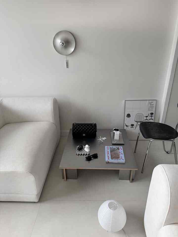 ミニマルでモダンな白とシルバーのリビング、3人掛けのファブリックソファとシルバーのソファテーブルが配置された雰囲気のあるインテリア