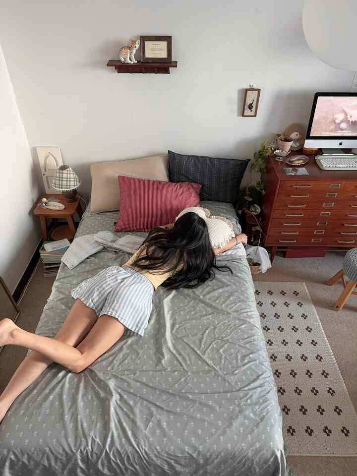 ナチュラルカラーの寝室、ベッドと枕、ドレッサーが調和した落ち着いた雰囲気のインテリア