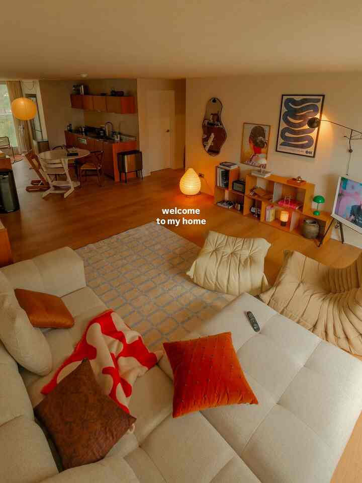 暖かい木目調とナチュラルベージュが調和するリビング、ソファとアームチェアが居心地よく配置された空間