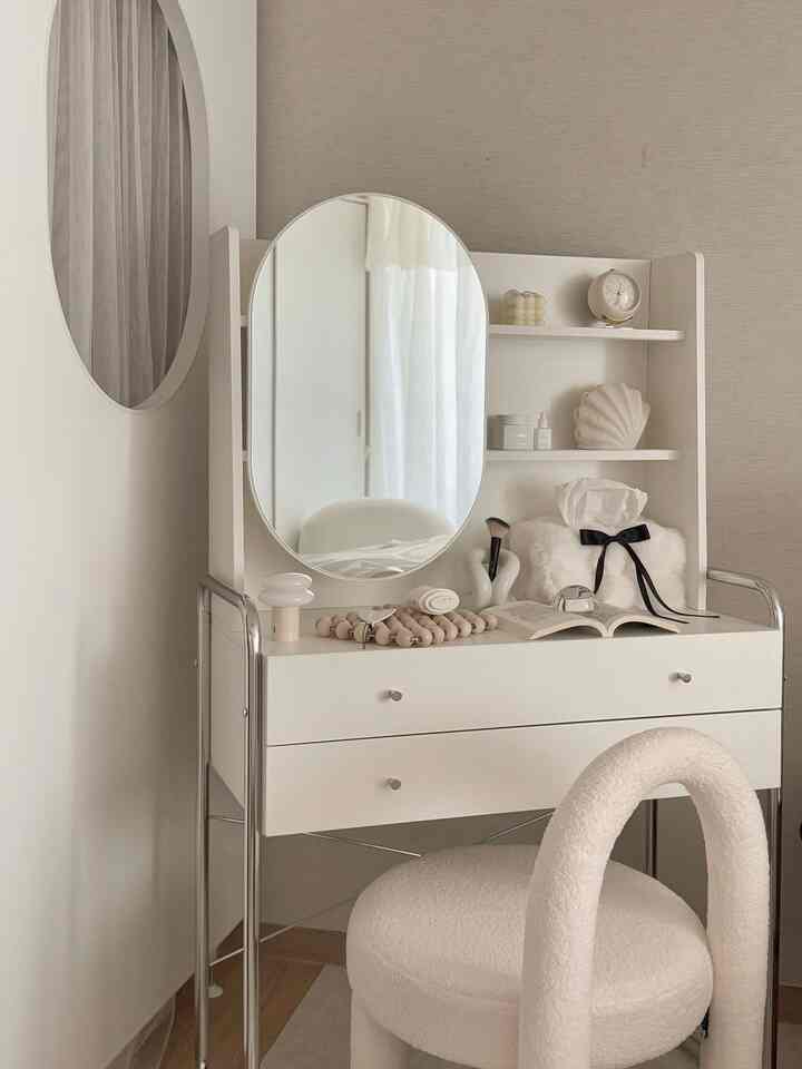 ホワイトとベージュの色調の寝室、スライディングミラーと3段シェルフが配置されたミッドセンチュリーモダンの化粧台がある落ち着いた空間