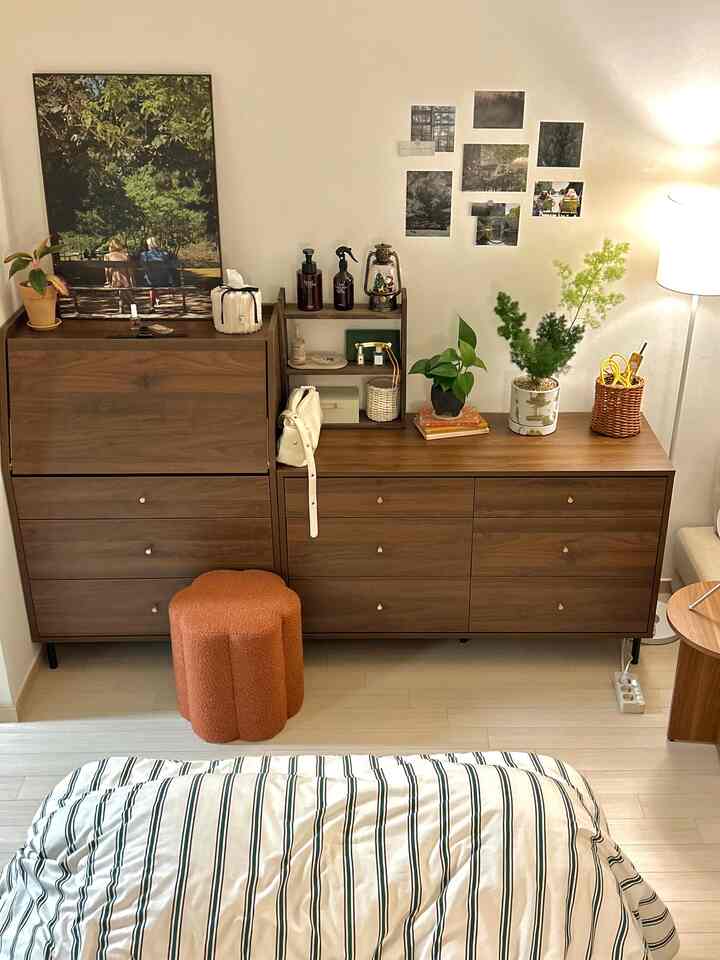 ブラウンの木目調とオレンジのブークレチェアが配置された居心地の良いワンルームの寝室