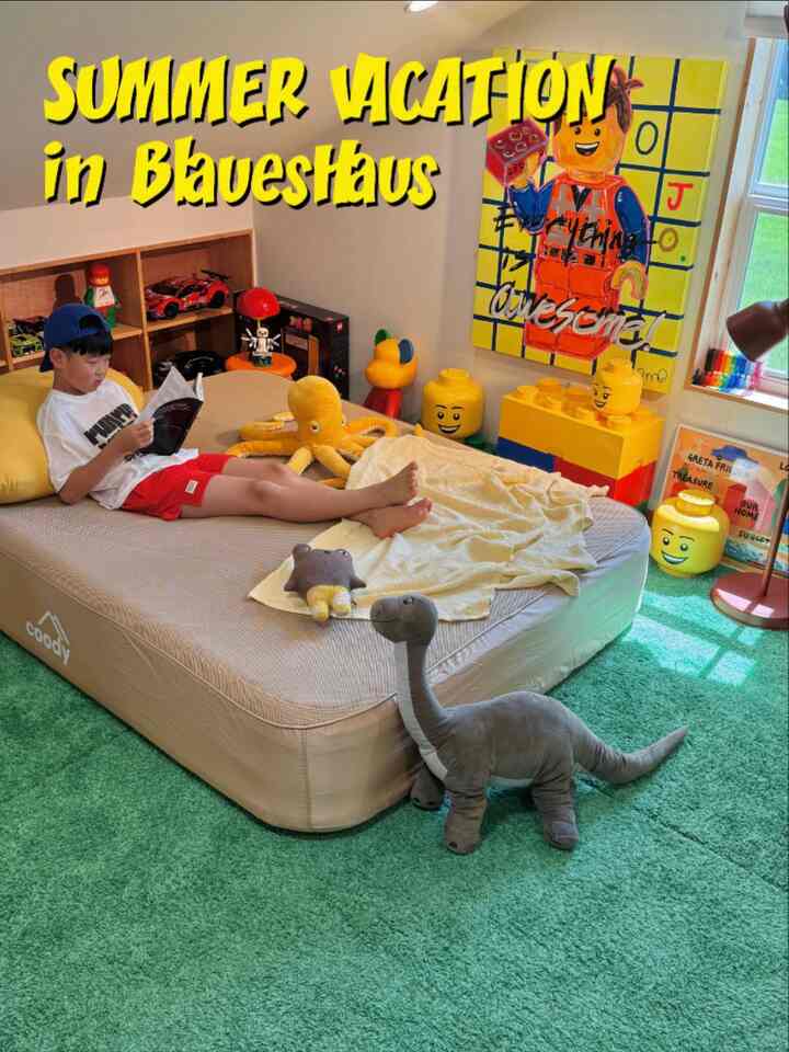 緑色のラグが敷かれた子供部屋、ベージュのベッドとレゴのおもちゃ収納が配置された雰囲気のあるインテリア