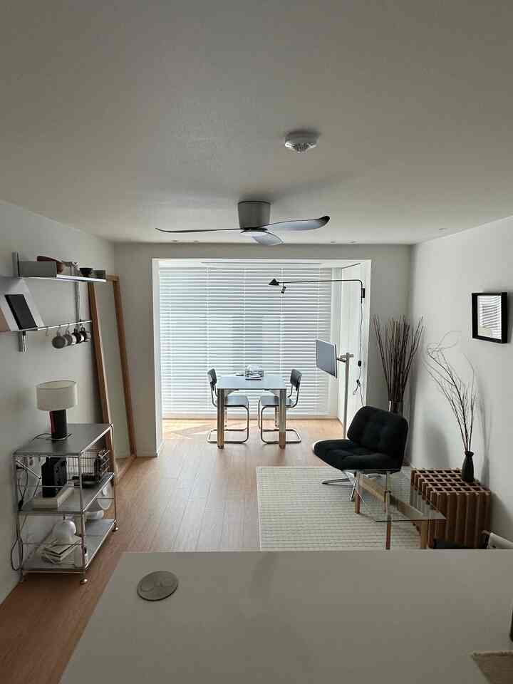 白い壁とナチュラルカラーの床が調和したモダンなダイニングルーム、スチール家具とアームチェアが配置された実用的で印象的な空間