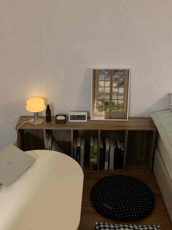 白と木目調のワンルーム6畳の部屋、座卓と本棚が配置された落ち着いた雰囲気のあるインテリア