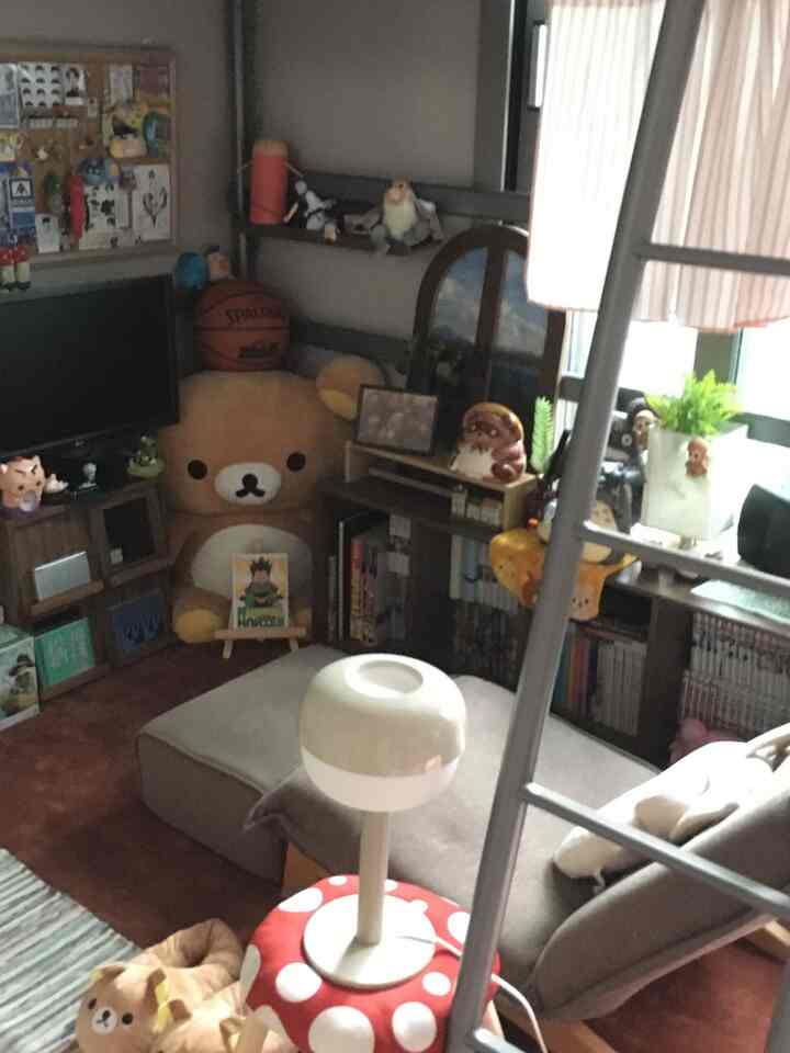 ブラウンとグレーの色調の子供部屋、二段ベッドと大きなテディベア、本棚とソファが配置された雰囲気のあるインテリア