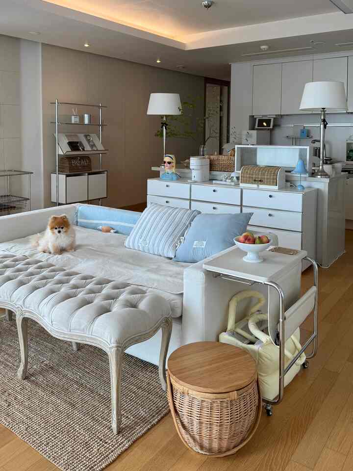 White and wood tone living room featuring sofa and rattan accessories with a cozy atmosphere