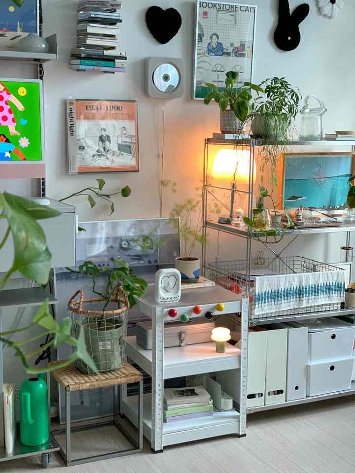 ホワイトとシルバーのトーンで統一された収納重視のナチュラルなインテリア、植物やポスターが配置された雰囲気のある空間