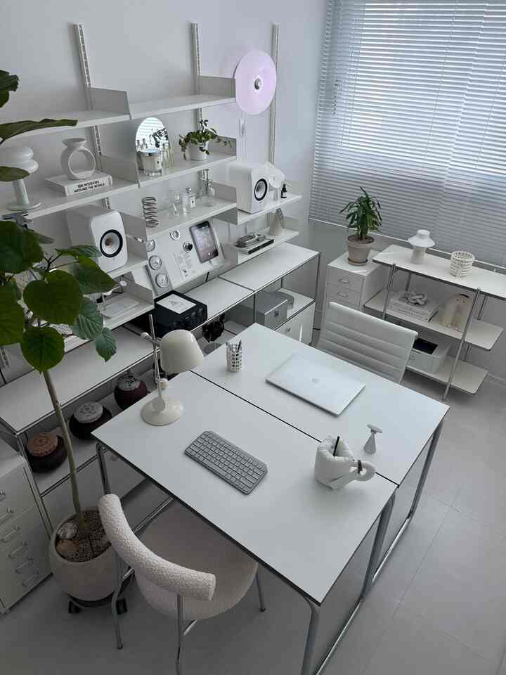 White-toned study featuring mid-century modern furniture and wall lighting, creating a clean and serene interior