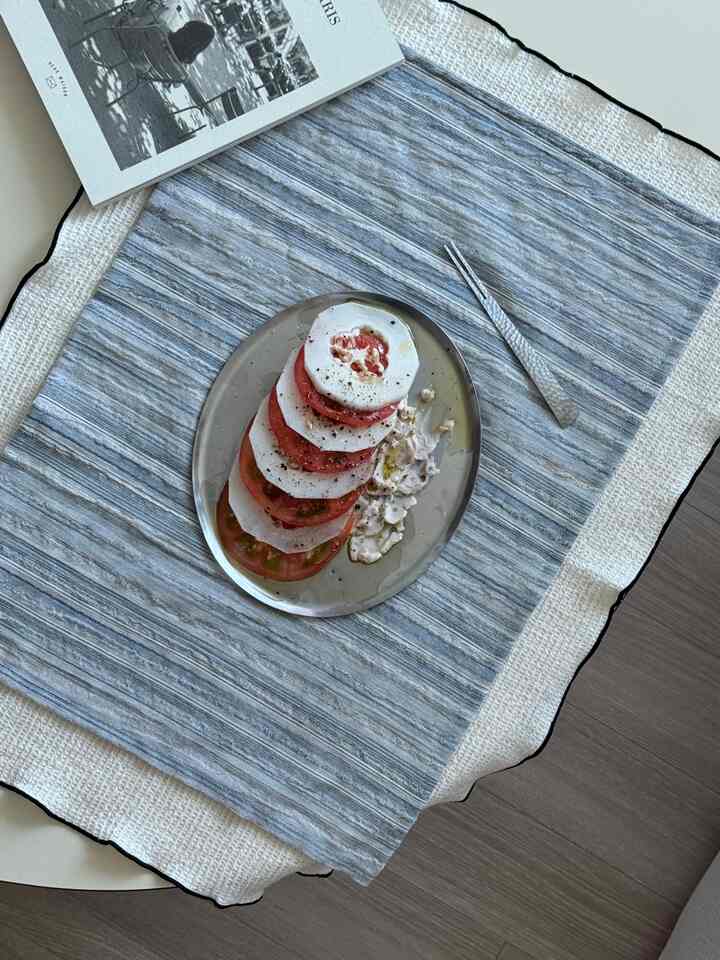 Gray-toned kitchen table setting featuring plate and cutlery with a simple atmosphere