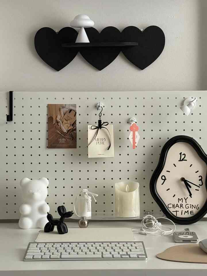 White and black toned desk interior featuring heart-shaped wall shelf and cute mood lamps on a tidy desk