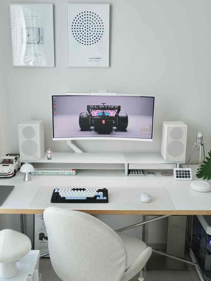 Clean white and gray toned home office featuring a large ultrawide monitor and organized desk in a minimal space