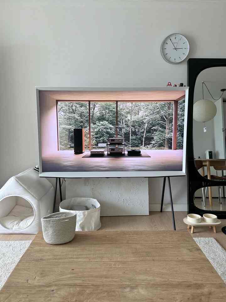 ホワイトと木目調のリビング、 大型テレビとペットハウスが配置された雰囲気のあるインテリア