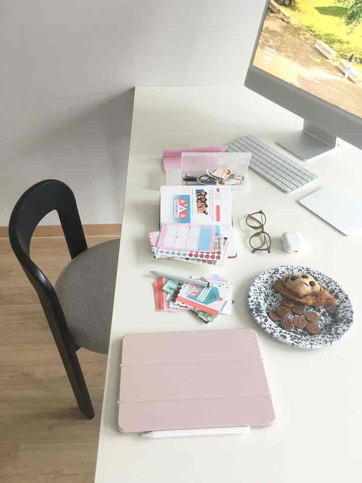 A modern white-toned studio apartment featuring a clean desk and office chair for remote work
