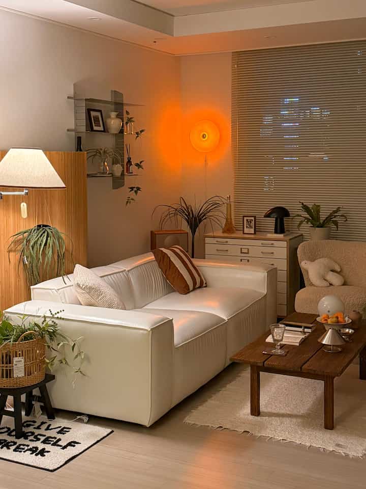 Warm brown and white mid-century modern living room featuring leather sofa and wood coffee table with cozy lighting ambiance