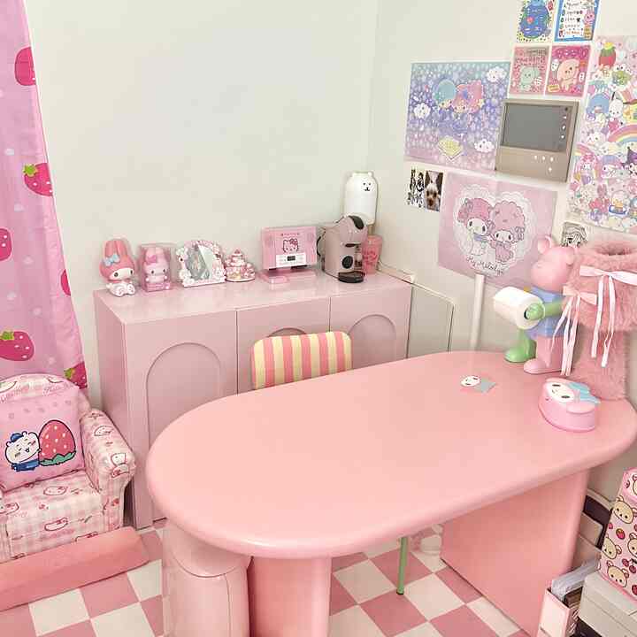 ピンクトーンのダイニングルーム、中央にピンクのダイニングテーブルと壁のポスターがかわいらしい雰囲気を演出する空間