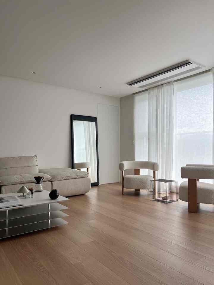 White and wood tone living room featuring natural modern sofa and armchairs with a cozy atmosphere