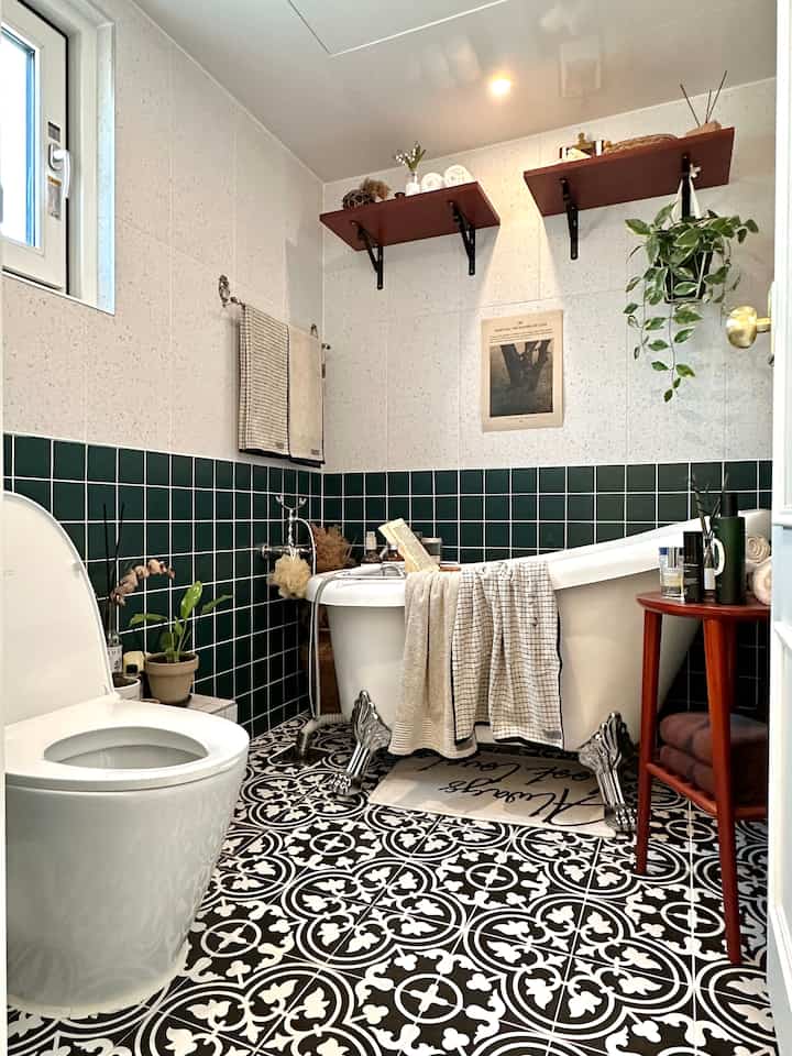 ホワイトとグリーンタイルのクラシックなバスルーム、猫足バスタブと白黒のパターン床が印象的な空間