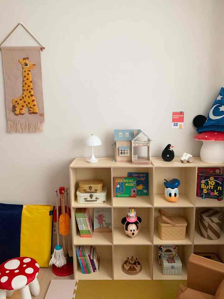 ナチュラルカラーの子供部屋、棚におもちゃと本が整理された雰囲気のあるインテリア