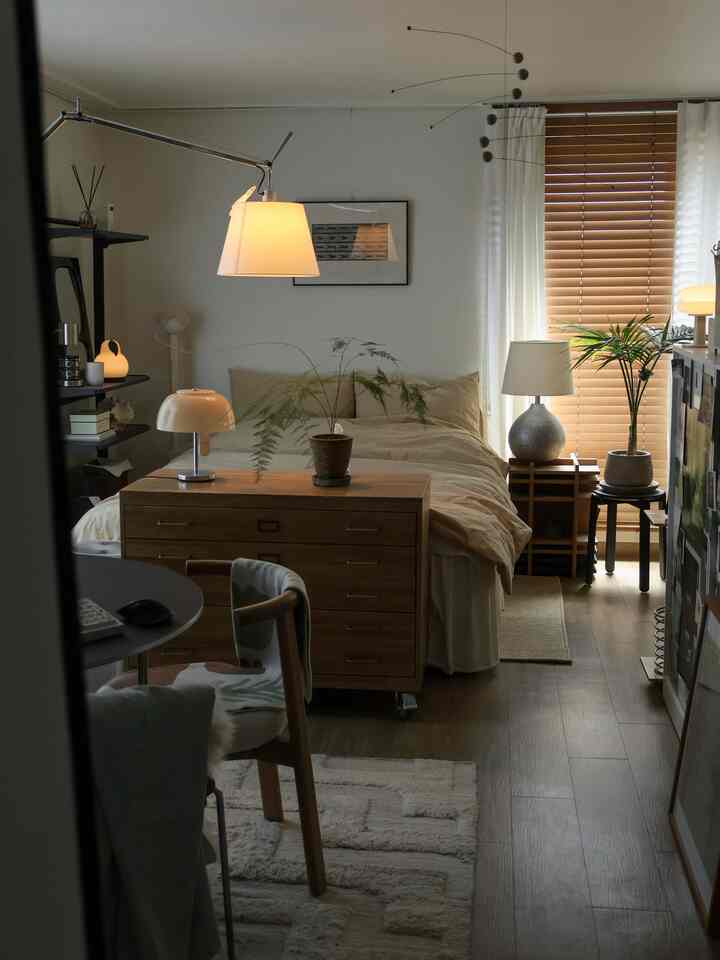 Beige and wood tone studio bedroom of approx. 8 pyeong, featuring plants and lighting in a natural modern style