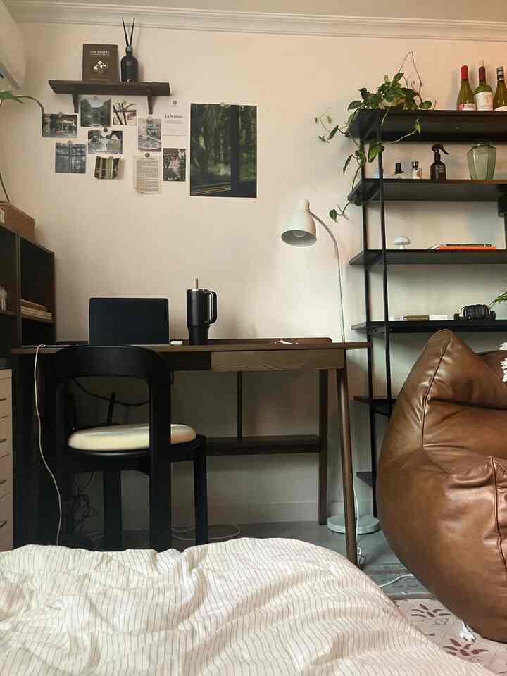 ナチュラルカラーのワンルーム、デスクとレザーのビーンバッグソファが配置された居心地の良いホームオフィス空間