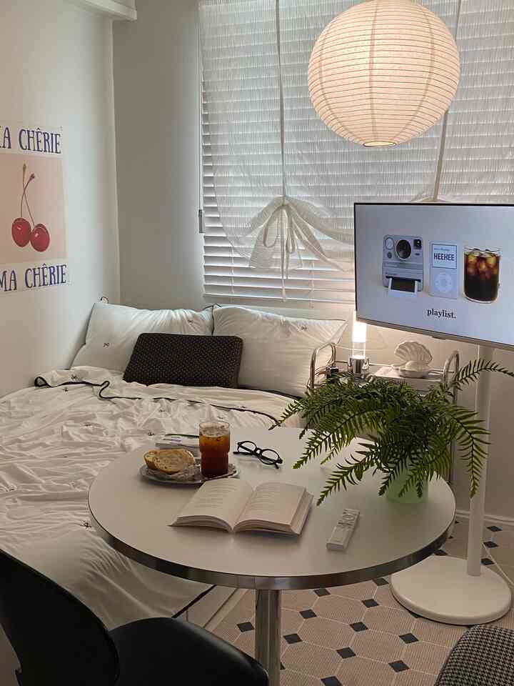 柔らかなホワイトトーンの寝室、中央に白いベッドと丸テーブル、和紙ランプが温かな雰囲気を演出するインテリア