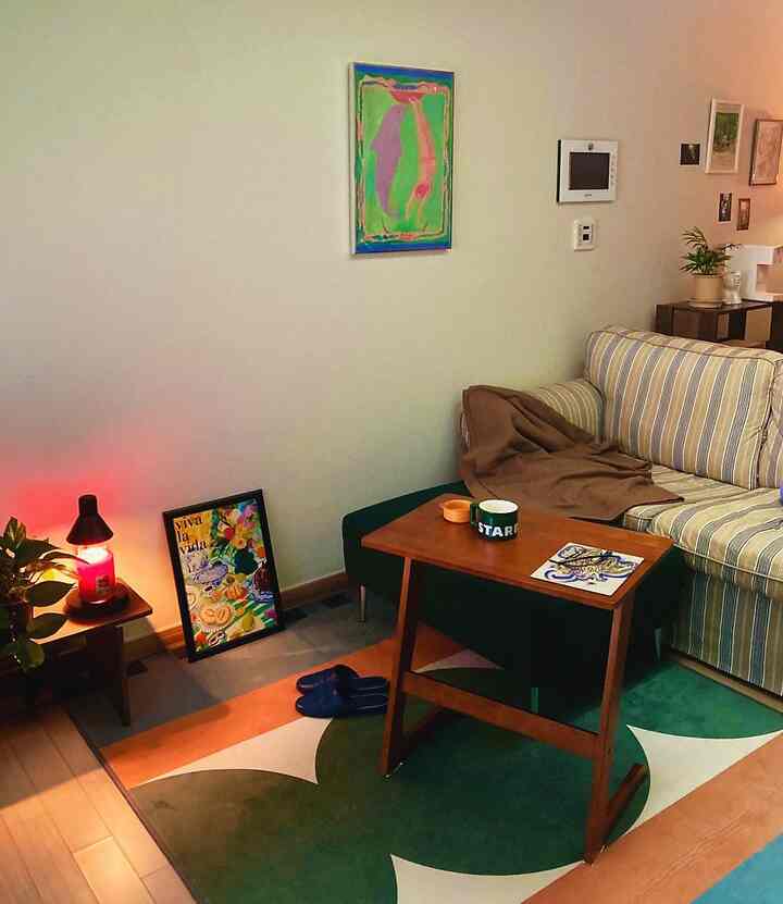 柔らかいナチュラルトーンのリビング、ストライプ柄のファブリックソファと木目調テーブルが調和した温かみのある空間