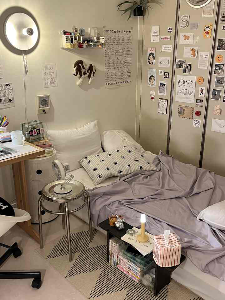 ベージュとホワイトの小さい寝室、クローゼット付きで壁照明とシンプルな家具が配置された雰囲気のある空間