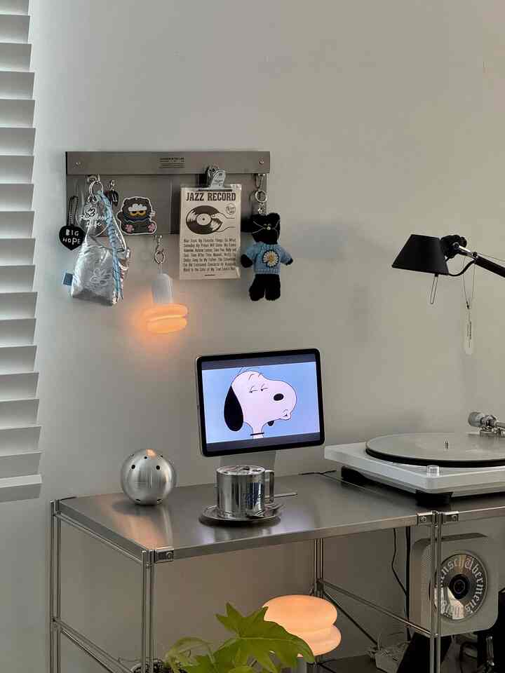 シルバー調のモダンな小さな部屋、スチール棚にデノンのターンテーブルとホームカフェ用マグが配置された雰囲気のある空間