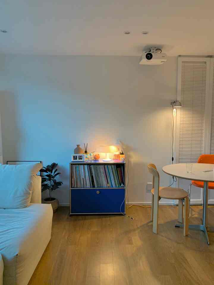 白と木目調の4人暮らし向けリビング、シンプルでナチュラルなブラインドと照明が配された雰囲気のあるインテリア