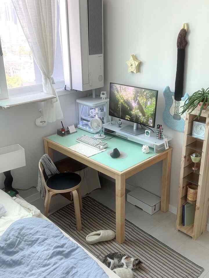白と木目調が調和したホームオフィス空間、デスクとモニター、猫がいるミニマルなコンパクトルーム